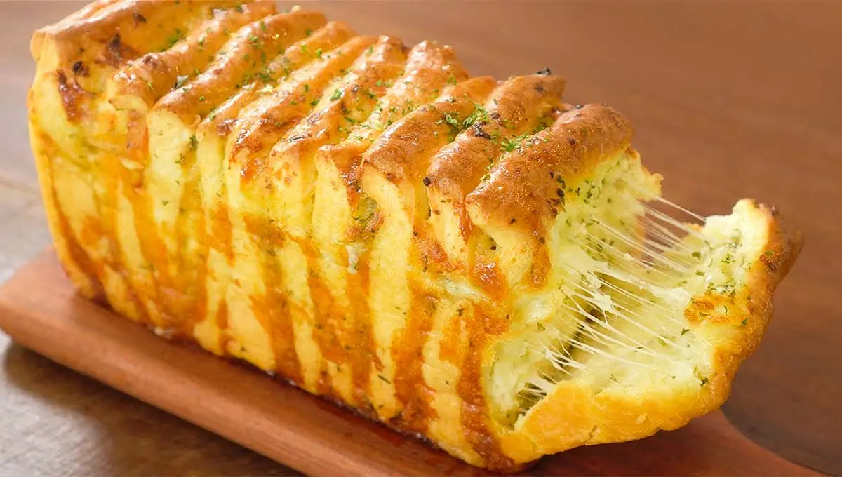 Esse pão de alho com cream cheese fica super fofinho, bem recheado e até já sai do forno fatiado!